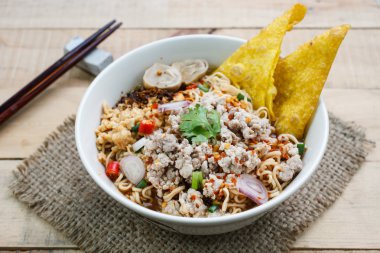 Ahşap zemin üzerine kıyılmış domuz eti ile baharatlı anlık erişte çorbası