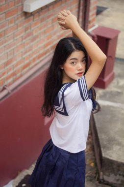 Japon öğrenci üniformalı güzel kız mutlu ve rahatlamış.