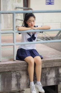 Japon öğrenci üniformalı güzel kız mutlu ve rahatlamış.