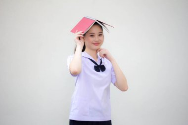 Asya thai ortaokul üniforması güzel kız bir kitap okudu.