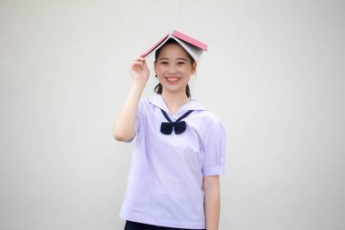 Asya thai ortaokul üniforması güzel kız bir kitap okudu.