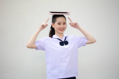 Asya thai ortaokul üniforması güzel kız bir kitap okudu.