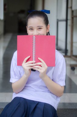 Asya Thai ortaokulu öğrencisi üniforması güzel kız gülümse ve rahatla