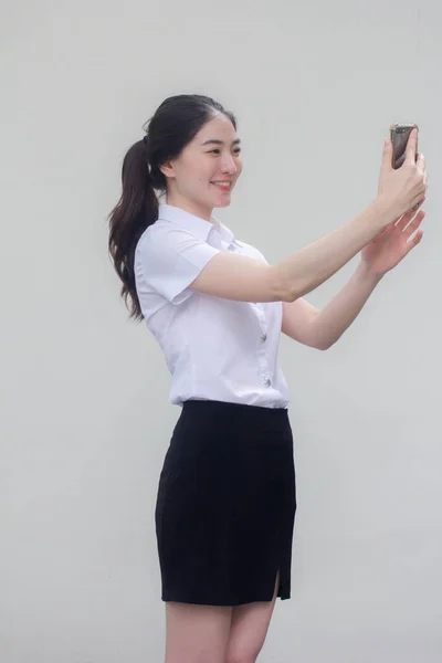 thai adult student university uniform beautiful girl using her smart phone Selfie