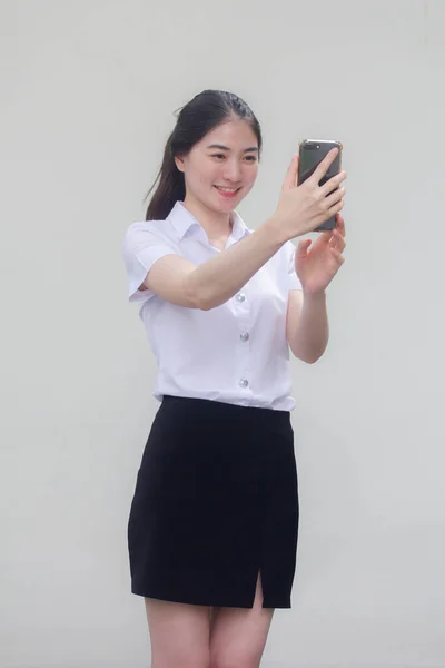 泰伊成人大学生制服漂亮的女孩使用她的智能手机自拍 — 图库照片
