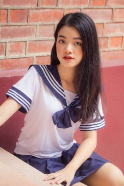 Japon öğrenci üniformalı güzel kız mutlu ve rahatlamış.