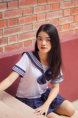 Japon öğrenci üniformalı güzel kız mutlu ve rahatlamış.