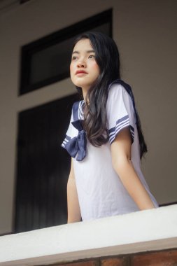 Japon öğrenci üniformalı güzel kız mutlu ve rahatlamış.