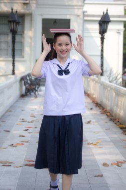 Asya Thai ortaokulu öğrencisi üniforması güzel kız gülümse ve rahatla