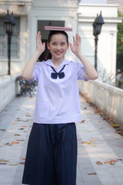 Asya Thai ortaokulu öğrencisi üniforması güzel kız gülümse ve rahatla