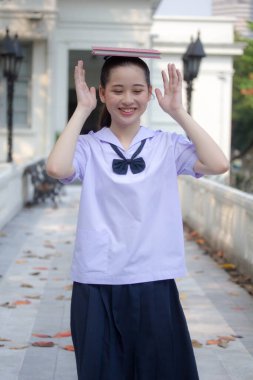 Asya Thai ortaokulu öğrencisi üniforması güzel kız gülümse ve rahatla