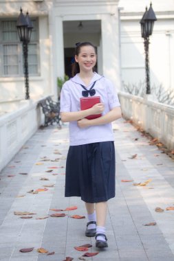 Asya Thai ortaokulu öğrencisi üniforması güzel kız gülümse ve rahatla