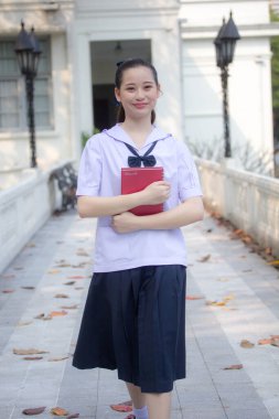 Asya Thai ortaokulu öğrencisi üniforması güzel kız gülümse ve rahatla
