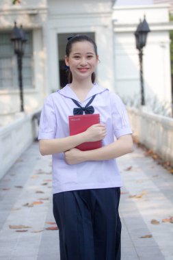Asya Thai ortaokulu öğrencisi üniforması güzel kız gülümse ve rahatla