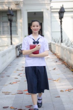 Asya Thai ortaokulu öğrencisi üniforması güzel kız gülümse ve rahatla