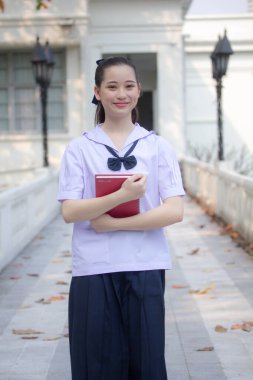 Asya Thai ortaokulu öğrencisi üniforması güzel kız gülümse ve rahatla