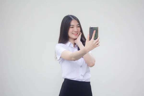 タイの成人女子大生制服美少女使用彼女のスマートフォンSelfie — ストック写真