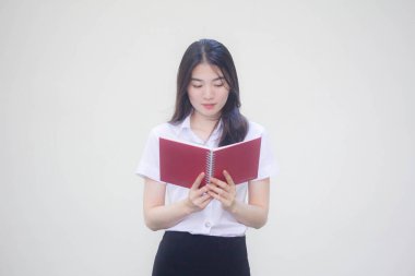 Taylandlı yetişkin üniversite üniforması güzel kız bir kitap okudu.