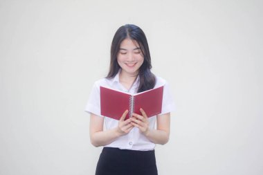 Taylandlı yetişkin üniversite üniforması güzel kız bir kitap okudu.
