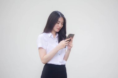 Yetişkin öğrenci üniforması. Güzel bir kız. Telefonunu kullanıp gülümsüyor.