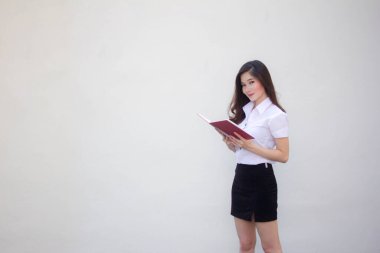 Taylandlı yetişkin üniversite üniforması güzel kız bir kitap okudu.