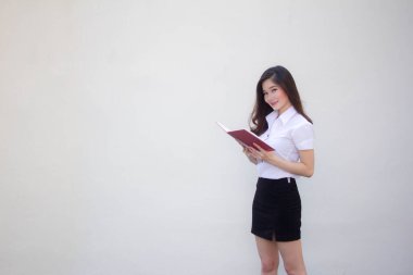 Taylandlı yetişkin üniversite üniforması güzel kız bir kitap okudu.