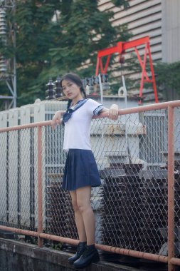 Japon öğrenci üniformalı güzel kız mutlu ve rahatlamış.