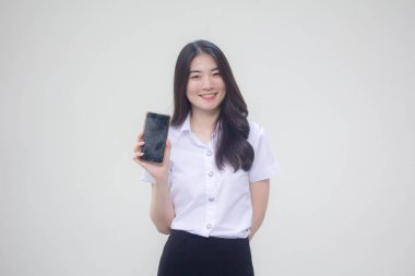 Taylandlı yetişkin üniversite üniforması güzel kız telefonunu göster ve gülümse.