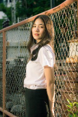 Yetişkin öğrenci üniforması güzel kız gülümse ve rahatla.