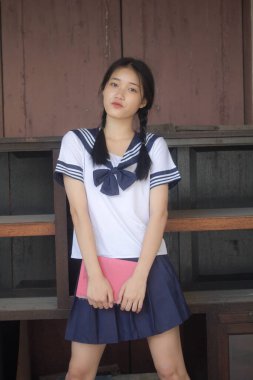 Japon öğrenci üniformalı güzel kız mutlu ve rahatlamış.