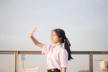 Taylandlı liseli üniformasının portresi. Genç güzel kız mutlu ve rahat.