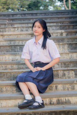 Taylandlı liseli üniformasının portresi. Genç güzel kız mutlu ve rahat.