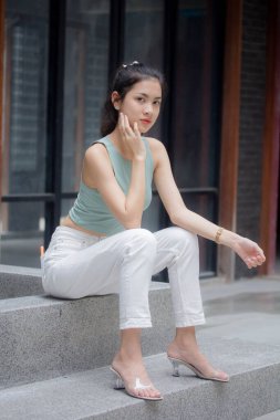 Tayland portresi yetişkin güzel kız yeşil gömlek beyaz pantolon rahatla ve gülümse