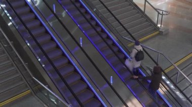 Alışveriş merkezindeki merdiven basamakları. İnsanlar alışveriş merkezinde yürüyen merdivene biniyor..