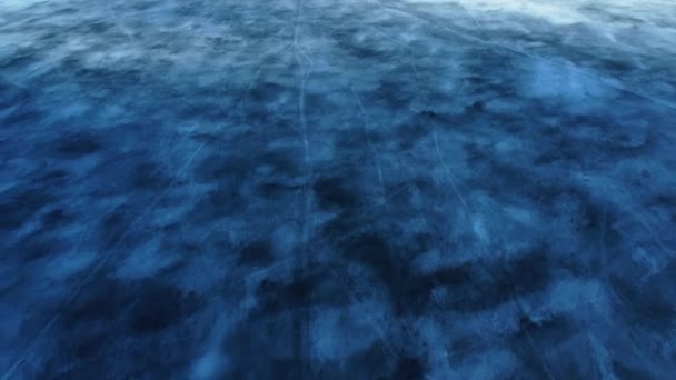 호수의 꽁꽁 얼어붙은 물 이 위로 내려다 보인다. 금이 가 있는 푸른 투명 한 얼음, 얼어붙은 호수의 꼭대기 사진. — 비디오