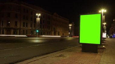 Krom anahtar yeşil ekranlı şehir sokak reklam panosu. Gece trafiğinin zamanlaması. Metin veya kopyalama için boşluk.