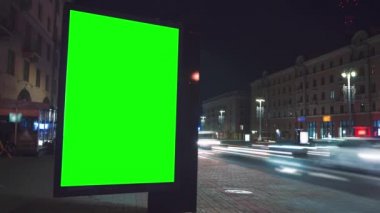 Gece sokakta krom anahtarı olan ilan panosu ve arka planda insanların ve arabaların zaman aşımına uğramış hareketleri.