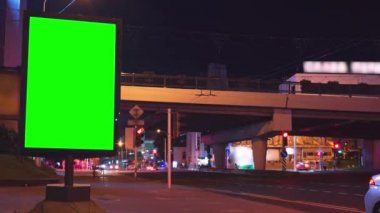 Gece sokakta krom anahtarı olan ilan panosu ve arka planda insanların ve arabaların zaman aşımına uğramış hareketleri.