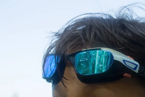 Islak saçlı genç bir adamın alnında yüzme gözlüğü. Yaz, eğlence ve spor konsepti