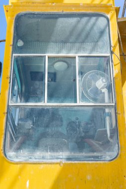 Sürücü taksisi ve yükleyici kontrol alanı. Taş ocağındaki bir inşaat alanında büyük, sarı bir kazıcı. Sanayi görüntüsü.