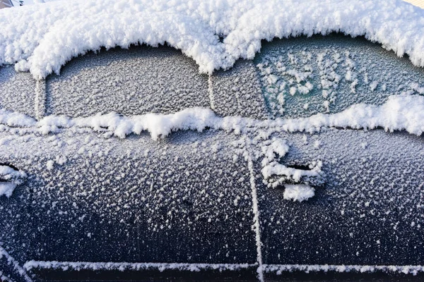 frozen car. the side of the car, doors and handles covered with snow and frost.