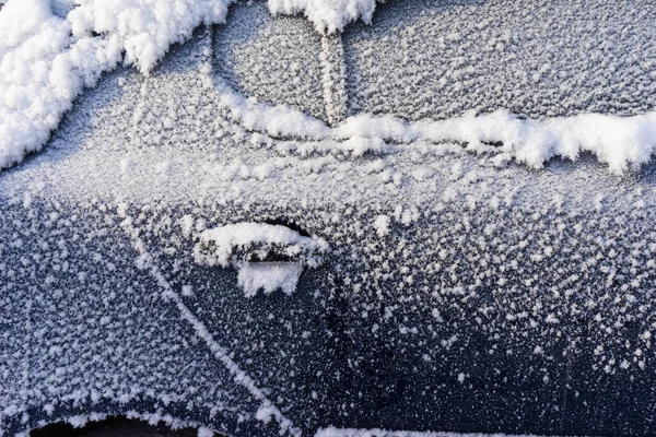 frozen car. the side of the car, doors and handles covered with snow and frost.