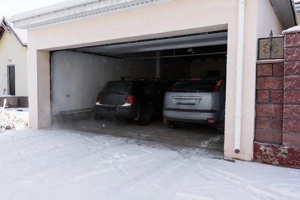 Снаружи Гаража Прикрепленного Дому Гараж Двумя Машинами Внутри Зимой Полуоткрытые — стоковое фото