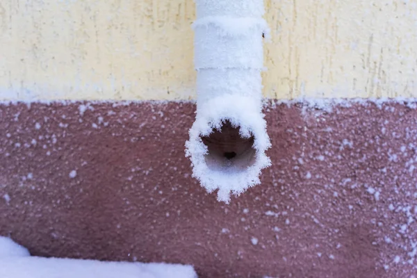 stock image frozen downpipe. .White downpipe on the wall covered with frost