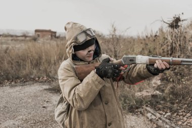 Gezgin çocuk. Silahlı bir çocuk. Çocuk terk edilmiş bir binaya gidiyor. Çocuk bir binanın önünde duruyor. Kıyametten sonra. Kıyamet sonrası bir dünyada yiyecek aramak için yayan seyahat eden bir adam.