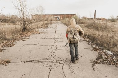 Gezgin çocuk. Silahlı bir çocuk. Çocuk terk edilmiş bir binaya gidiyor. Çocuk bir binanın önünde duruyor. Kıyametten sonra. Çocuk, kıyamet sonrası bir dünyada yiyecek aramak için yaya olarak seyahat ediyor..