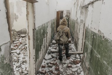 Genç bir çocuk terk edilmiş bir sığınağın yanında duruyor.