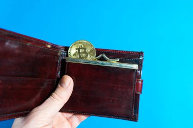 Deri cüzdanda Bitcoin altın para. Bitcoin bir adamın elinde.