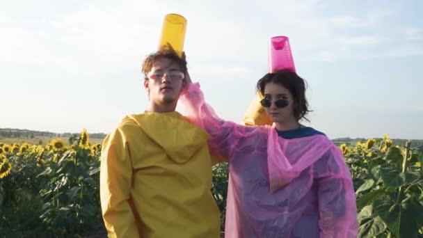 Two Figures Man Woman Yellow Pink Raincoats Background Field Sunflowers — Stock Video