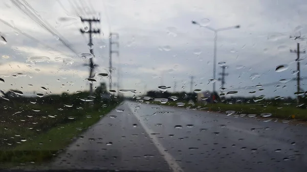 The water drops cover the glass with storm clouds in background